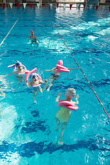 happy children kids group at swimming pool class learning to swim