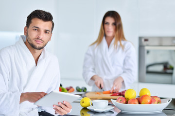 Happy couple cooking breakfast together in the kitchen