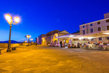 Alghero cityscape seen from the harbor at night, Italy