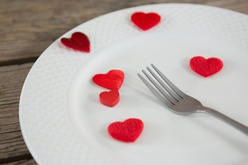 White plate with red hearts and fork