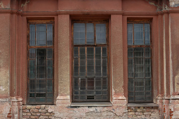 Old building facade with window. Facade of old abandoned building with three large windows.