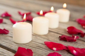 Burning candles surrounded with aromatic rose petals