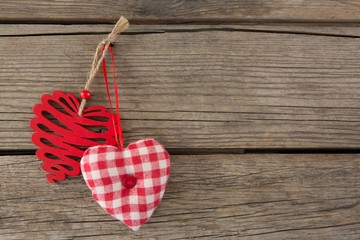 Two heart shape decoration hanging on wooden plank