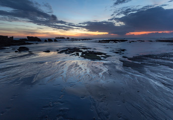 low tide with patterns under beautiful sunset at mengening beach, Bali