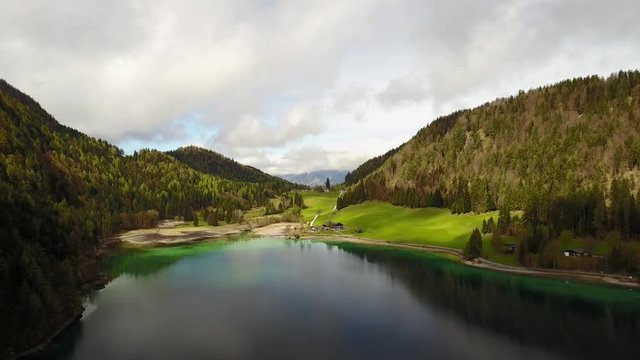 Aerial: flying over Hintersteiner Mountain lake with clear water in Austria and beautiful cloud reflections