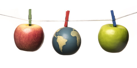 Earth and apples are hung from a rope with clothespins. Isolated on white background. Studio Shot.