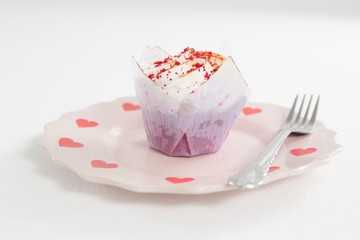 Delicious cake with red icing on plate