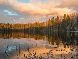 Mirror of the lake reflects a bright sunset in the water
