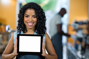 Portrait of smiling waitress showing digital tablet