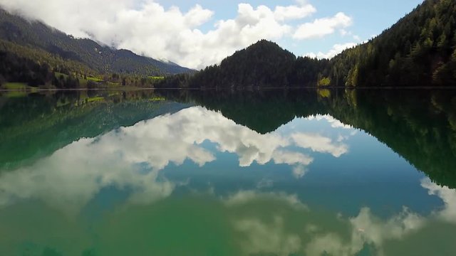 Aerial: flying over Hintersteiner Mountain lake with clear water in Austria 