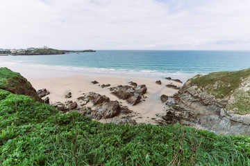 Beach ocean with rocks and blue sky in Cornwall