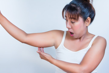 asian woman checking her fat upper arm and she agape