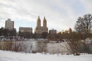 Fototapeta premium Buildings in Manhattan behind lake and snow at Central Park