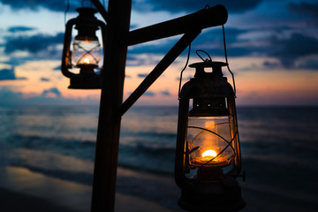 Sunset on an island beach with lanterns illuminating the scene