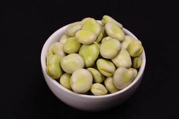 A bowl of fresh green broad beans.