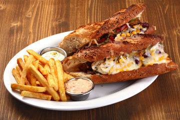 steak sandwich with cheese and potatoes and sauce