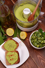 Toast with bean paste and boiled broad beans on wooden background.