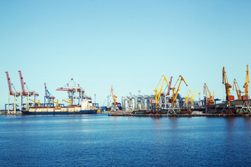 Naklejka premium Panorama of a seaport with cargo cranes and a ship with freight containers