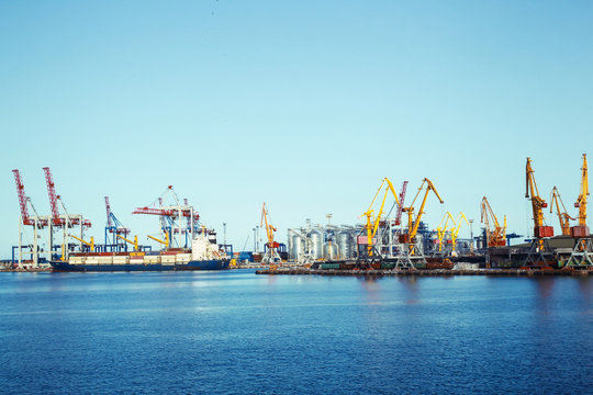 Panorama of a seaport with cargo cranes and a ship with freight containers