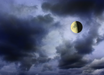 Moon glowing in the dark cloudy sky