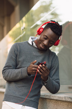 African american man with headphones listen music in city