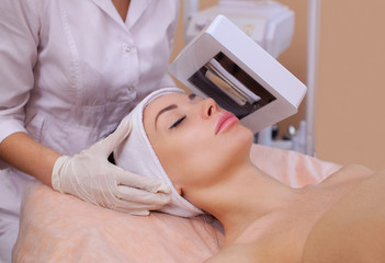 Cosmetologist diagnose with wood's lamp skin disease, and also reveals inflamed areas on the face of the patient. © Dimid