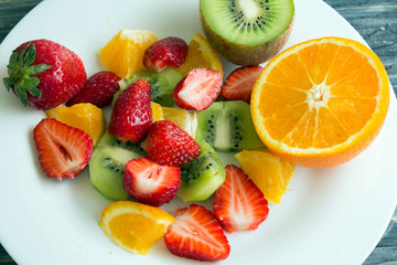 Sliced fruit on a white plate. Delicious dessert. Healthy food.