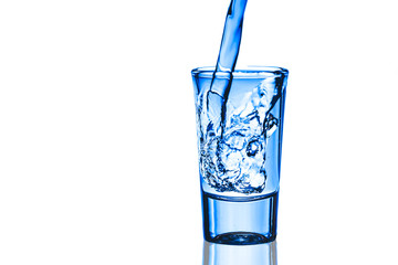 Pouring vodka into glass vodka shot ioslated on white.