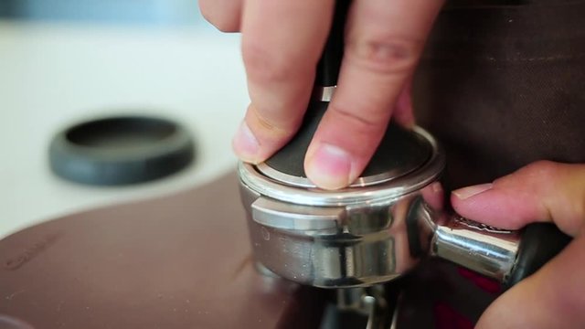 Barista presses a ground coffee.