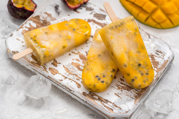 Homemade frozen popsicles with fresh mango and passion fruit