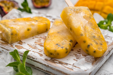 Homemade frozen popsicles with fresh mango and passion fruit