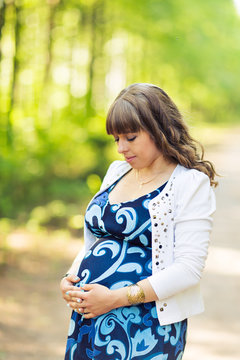 Portrait of pregnant woman relaxing and enjoying life in nature.