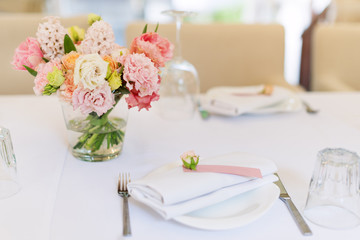 Flower table decorations for holidays and wedding dinner. Table set for holiday, event, party or wedding reception in outdoor restaurant.