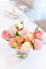 Flower table decorations for holidays and wedding dinner. Table set for holiday, event, party or wedding reception in outdoor restaurant.