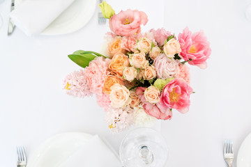 Flower table decorations for holidays and wedding dinner. Table set for holiday, event, party or wedding reception in outdoor restaurant.