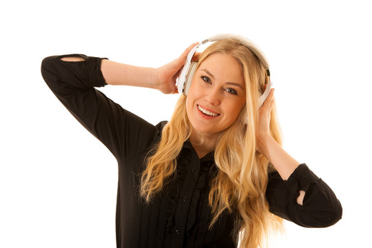 Beautiful young woman listens to the music on headphones and dance isolated over white background