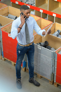 Worker In Plumbing Supplies Shop, Using Telephone