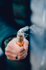 vaping man holding a mod device. cloud of vapor. Vape. Electric cigarettes
