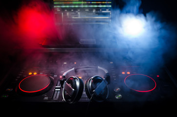 DJ Spinning, Mixing, and Scratching in a Night Club, Hands of dj tweak various track controls on...