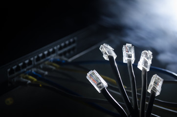 Network switch and ethernet cables, symbol of global communications. Colored network cables on dark...