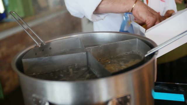Chief puts spaghetti into boiling water. Close up of cooking macaroni. Macaroni is thrown into hot water. Preparation pasta. Cook food.