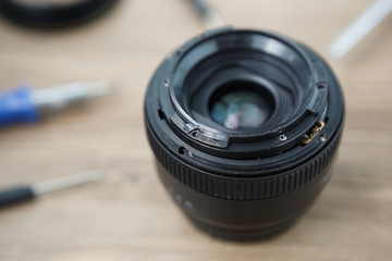 Fototapeta na wymiar Broken DSLR lens repair service in workshop