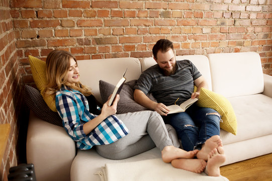 Couple reading books in living room