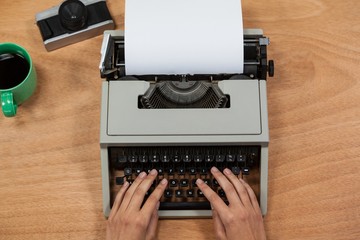 Businesswoman typing on typewriter with vintage camera