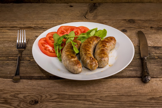 Plate of sausages on the wood background