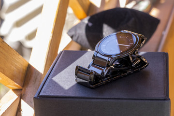 Luxury mens watch made of black high-tech ceramics with original packaging. Close-up photo.