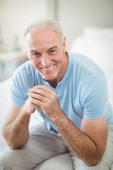 Portrait of smiling man sitting on bed