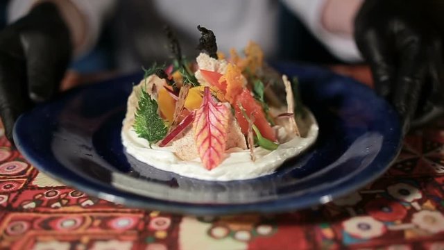 Closeup chef in white uniform presenting delicious vegetable salad. Slow motion