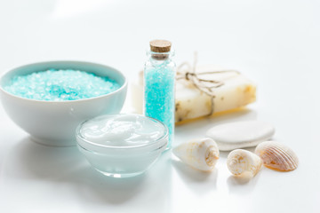 Plakat blue sea salt, soap and body cream on white desk background