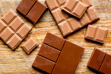 black and milk chocolate bars with mint dark wooden table background top view